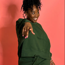 Load image into Gallery viewer, Black girl smiling and wearing green jogger set and standing in front of pink background
