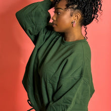Load image into Gallery viewer, Black girl wearing green jogger set and standing in front of pink background
